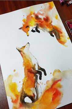 someone is painting a fox with watercolors on paper