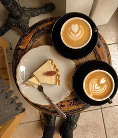 two cups of cappuccino coffee and one slice of pie