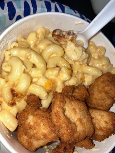 a white bowl filled with macaroni and cheese next to fried chicken nuggies