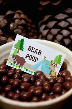 a bowl filled with chocolate covered candies and a sign that says bear poop