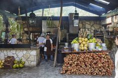 there are many people that are standing at the counter in this market place with food on it