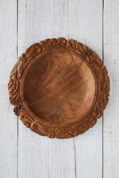 a wooden plate sitting on top of a white table