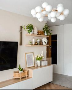 a living room filled with furniture and a flat screen tv on top of a wooden shelf