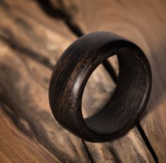 a wooden ring sitting on top of a piece of wood with no one around it