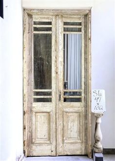 an old wooden double door with glass panels