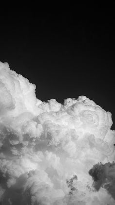 an airplane is flying high in the sky with clouds behind it and black and white photograph