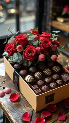 a box filled with chocolates and roses on top of a table