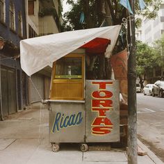 a food cart sitting on the side of a street