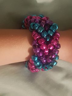 a close up of a person's arm wearing a bracelet with beads on it