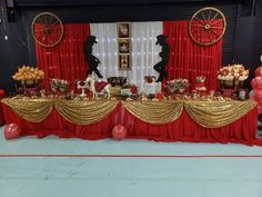 a table set up with red and gold decorations