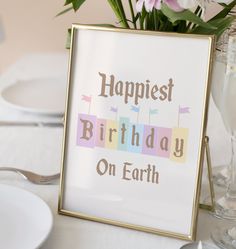 a happy birthday sign sitting on top of a table next to plates and silverware