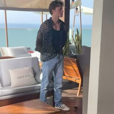 a man standing on top of a wooden floor next to a couch and coffee table