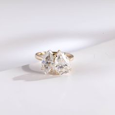 three stone ring sitting on top of a white surface