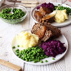 two plates with meat, mashed potatoes and green peas