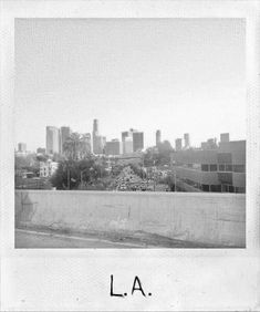 a black and white photo with the word la on it in front of a cityscape