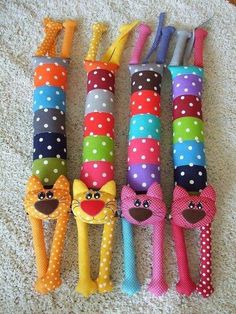 four colorful stuffed animals are lined up on the floor with toothbrushes in them