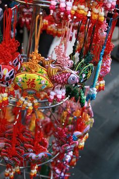 many colorful beads and necklaces are hanging from the ceiling