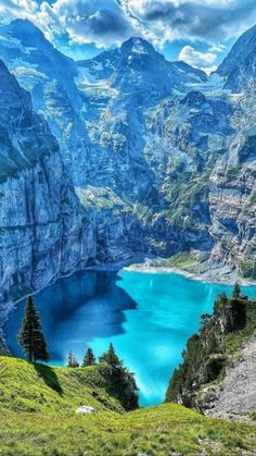 a mountain lake surrounded by mountains with blue water