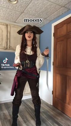 a woman dressed as a pirate standing in front of a door with the caption moony