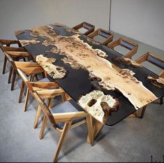 a table made out of wood with chairs around it and an artistic design on the top