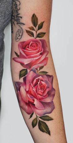 a woman's arm with three pink roses on it