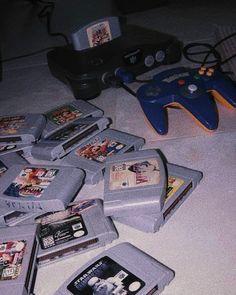 a bunch of video games sitting on top of a table next to a game controller