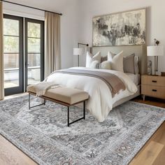 a large bed sitting in a bedroom on top of a wooden floor next to a window