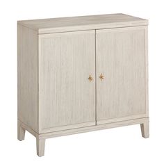 a white cabinet with two doors and gold handles