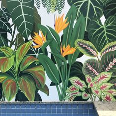 a painting of tropical plants and flowers on a wall next to a pool with blue tiles