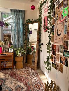 a living room filled with lots of plants and pictures on the wall above a mirror