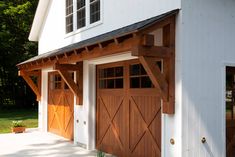 a white house with two brown garage doors