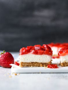 two slices of cheesecake with strawberries on the side