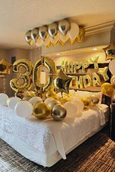 an image of a birthday party with gold and white balloons in the shape of numbers