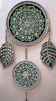 an intricately decorated wall hanging with green and white designs