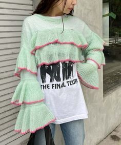 a woman standing next to a building wearing a sweater with the words, the final tour on it