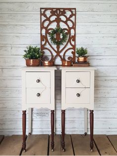 two white nightstands with plants on top