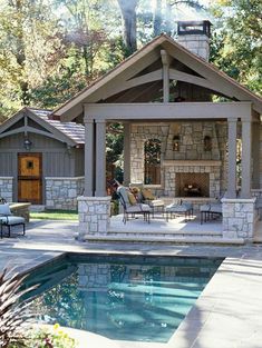 an outdoor living area next to a pool with a fire place in the middle and chairs around it