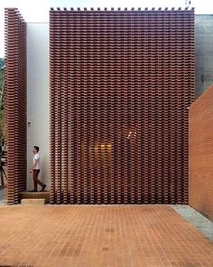 a man walking past a building made out of bricks