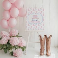 pink flowers and balloons are next to a sign that says baby's first birthday