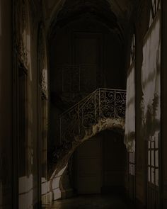 an empty hallway with a staircase and light coming through the windows