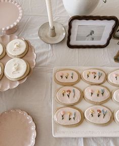 a table topped with lots of cookies and other desserts next to a vase filled with flowers