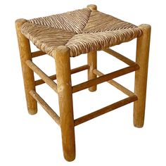 a wooden stool with a woven seat cushion on the back and sides, made out of natural wood