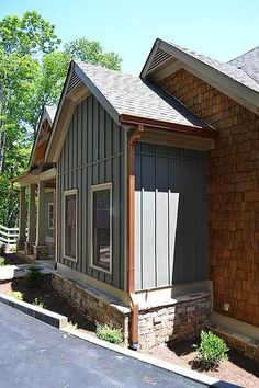 the front of a home with brick and shingles on it's side walk