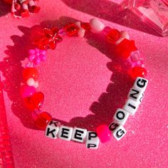 a bracelet for reminding you to keep going! 💕 details ❥ approximately 6.5 inches & super stretchy 🐛 ❥ can be adjusted to your sizing :) 🌈 ❥ want this same design but want it to say something else? i can do that ☎️ Kpop Style Friendship Bracelets With Round Beads, Pink Beaded Kpop Bracelets, Kpop Style Beaded Bracelets As Gift, Pink Kpop Beaded Bracelets, Kpop Pink Beaded Bracelets, Cute Bracelet Wristband With Letter Beads, Cute Wristband Bracelet With Letter Beads, Kawaii Beaded Bracelets As A Gift, Kawaii Beaded Bracelets For Gift