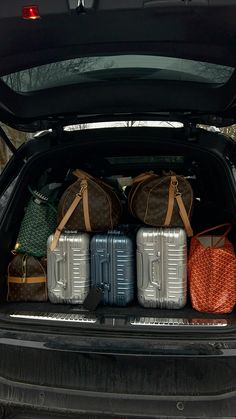 three suitcases are sitting in the back of a car