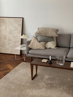 a living room with a couch, coffee table and lamp on top of the floor