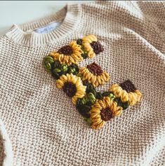 a knitted sweater with sunflowers on it