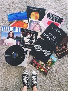 a person's feet are on the ground with books, cds and other items