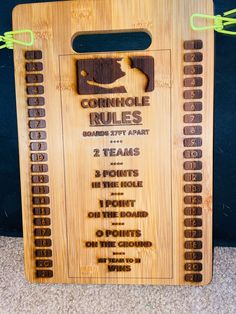 a wooden sign with instructions on how to play cornhole rules in the game room