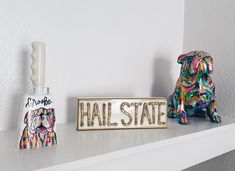 a dog figurine sitting on top of a shelf next to a sign that says hall state